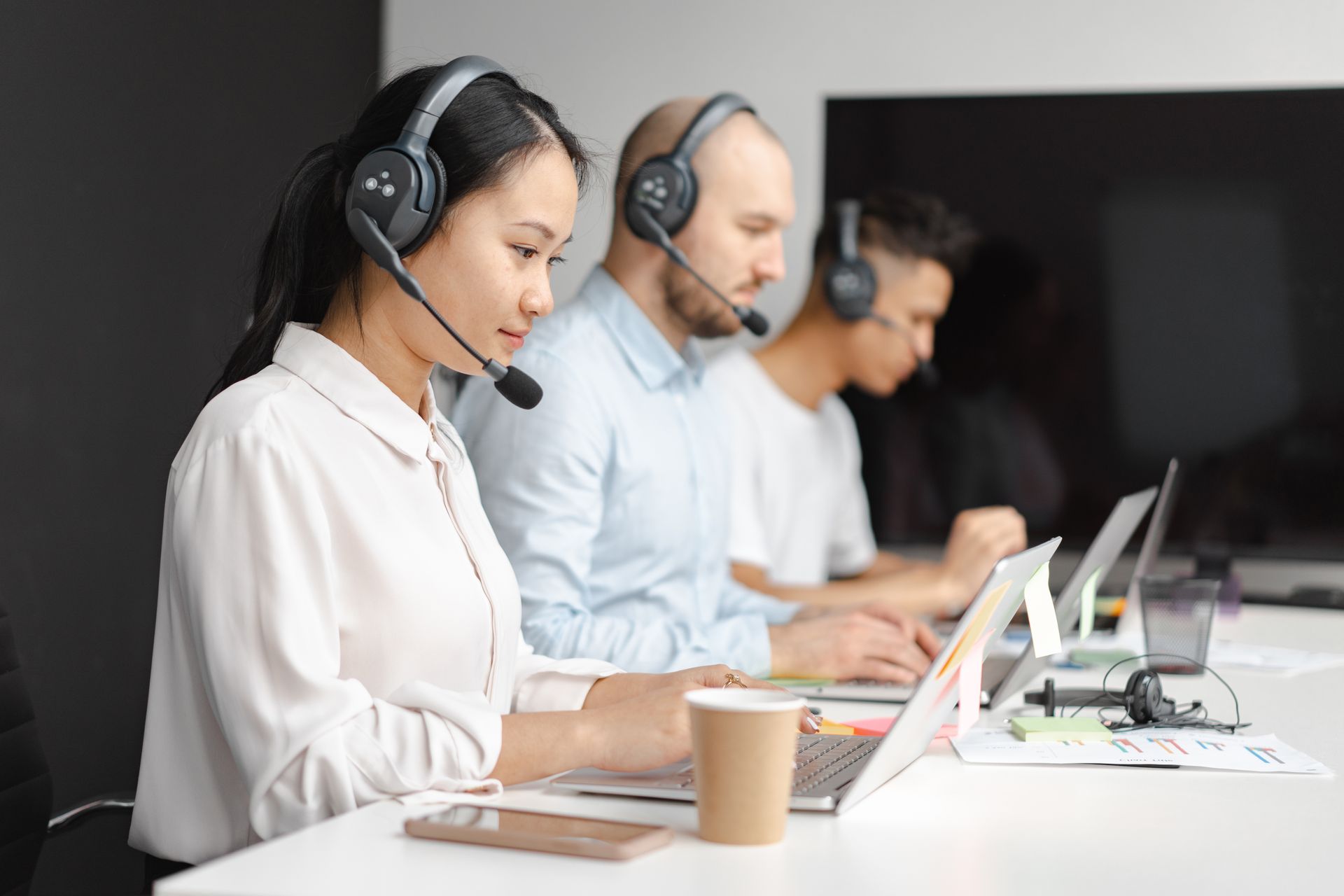 Equipe de atendimento ao cliente utilizando headsets em central de contato