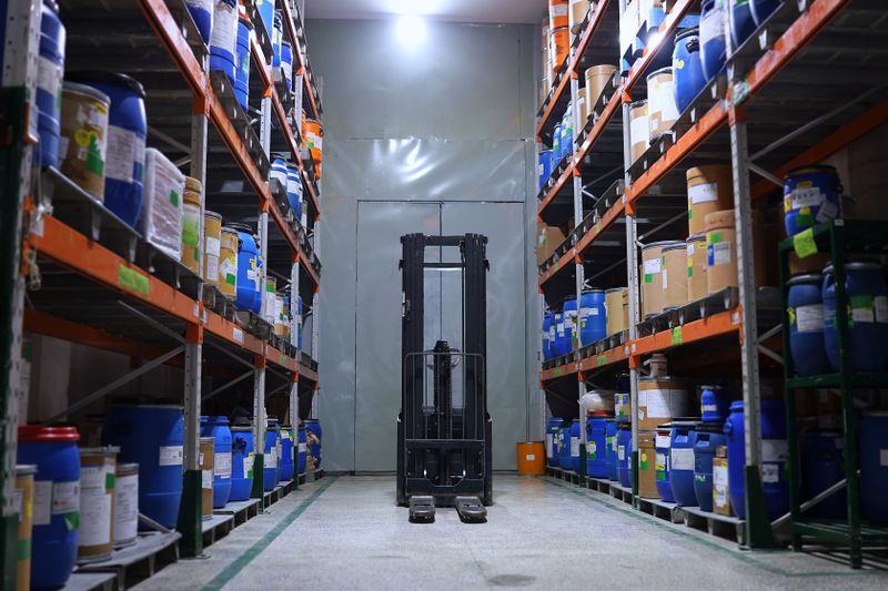 Distribuição de medicamentos: colaborador organizando caixas em centro de distribuição hospitalar