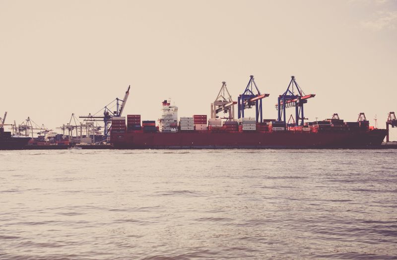 Gestão de suprimentos e importação: navio cargueiro carregado de contêineres atracado em porto